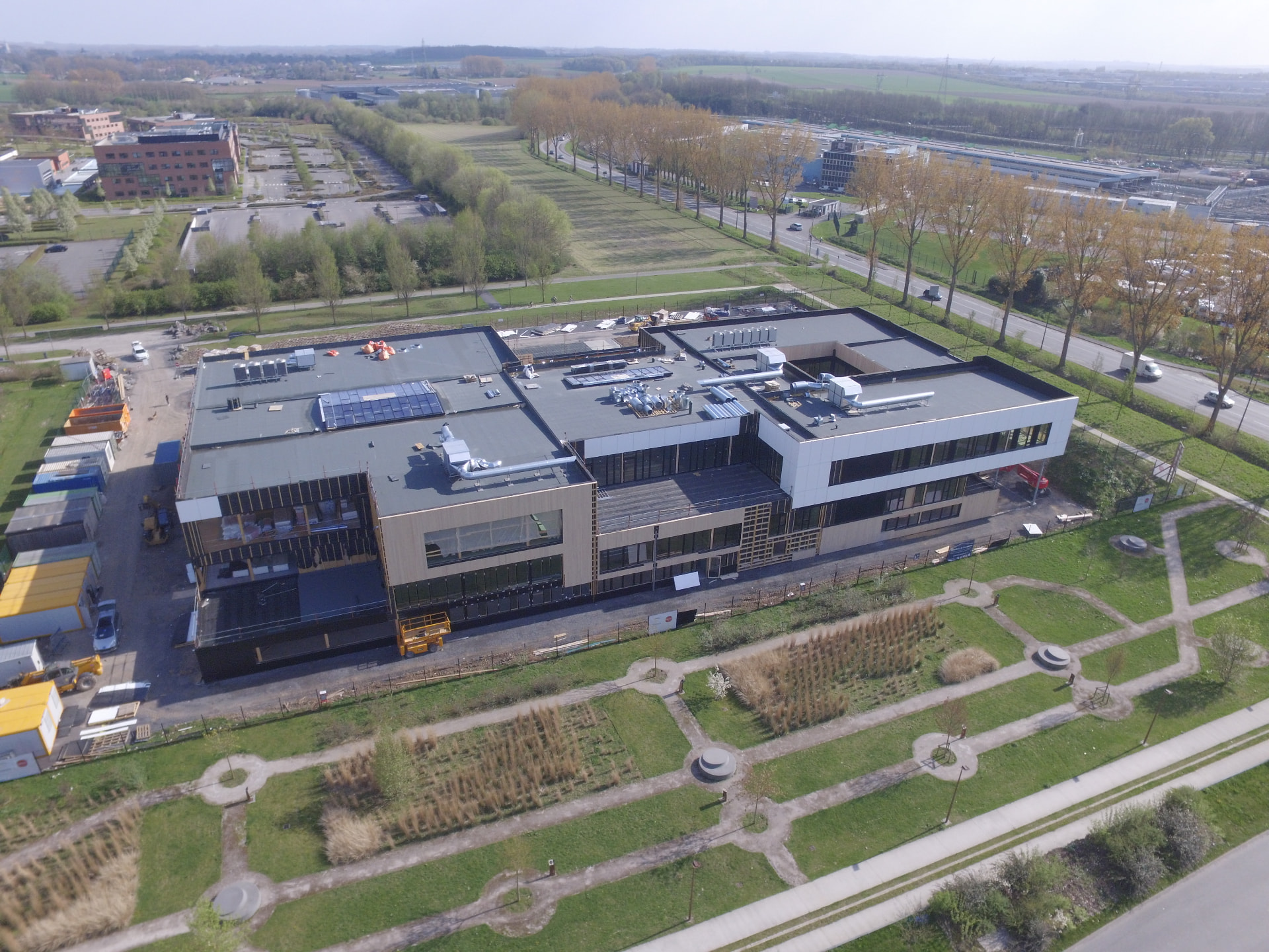 Aerial view of a large contemporary building complex with flat roofs and surrounding roads